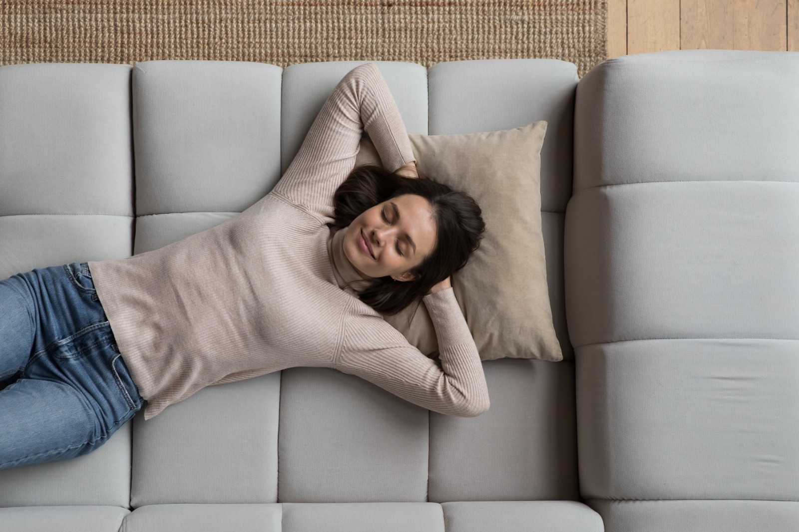 Feliz relajada y bella joven mujer tendida en el sofá de casa, soñando despierto, pensando en buenos planes de futuro, respirando aire fresco, disfrutando del tiempo libre, pausa, pereza, recarga. Vista superior