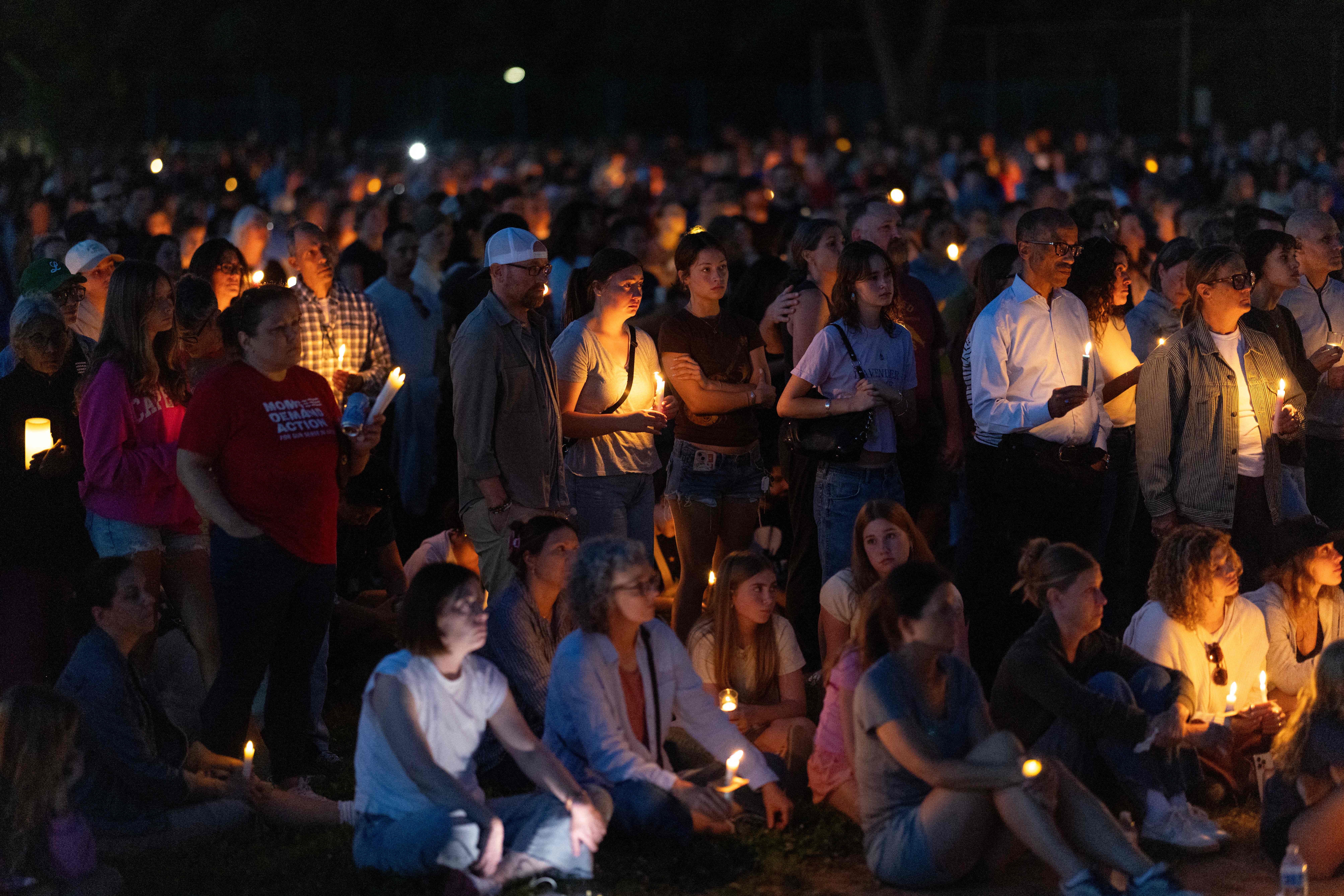 Cientos de personas guardan un minuto de silencio en las afueras de la escuela. (Foto Prensa Libre: AFP)