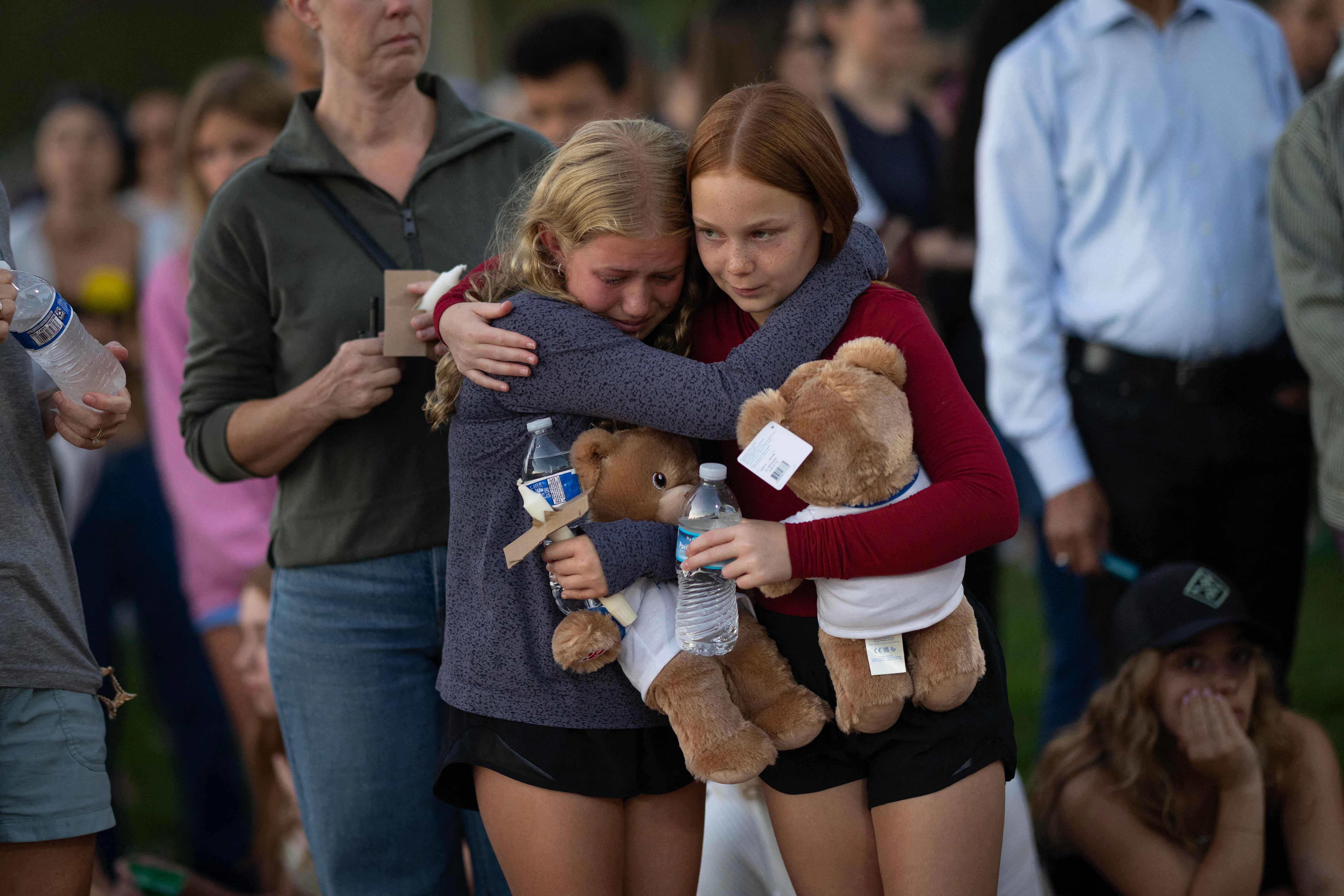 Niños depositan peluches y flores como símbolo de duelo y esperanza. (Foto Prensa Libre: AFP)
