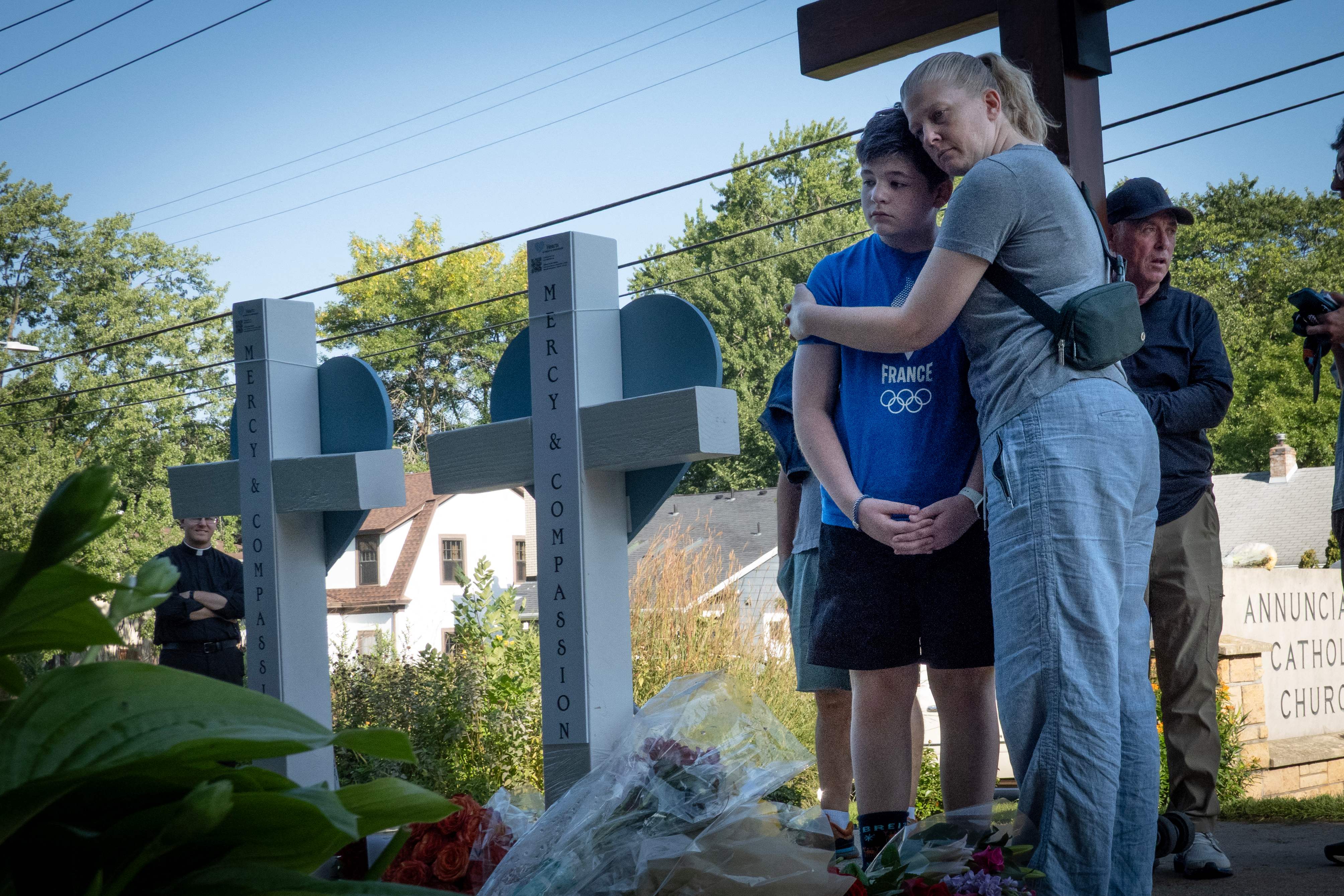 Padres de familia abrazan a sus hijos durante la vigilia en Minneapolis. (Foto Prensa Libre: AFP)