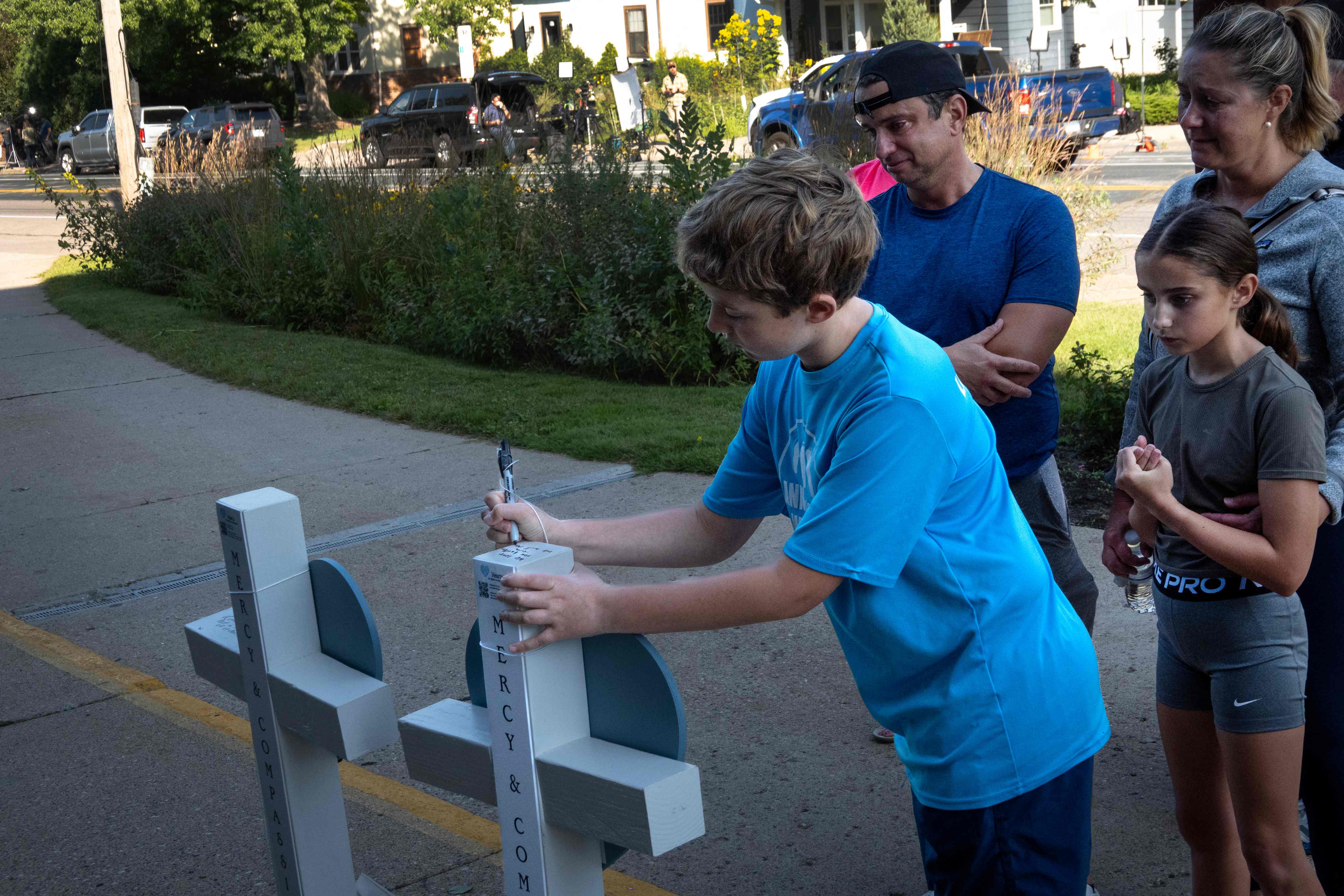 Mensajes religiosos acompañan las ofrendas depositadas en las afueras de la escuela.  (Foto Prensa Libre: AFP)