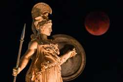This photograph shows a full moon also known as "Blood Moon" during a lunar eclipse with  a statue of ancient Greek goddess Athena in the foreground, in central Athens, on September 7, 2025. (Photo by Angelos TZORTZINIS / AFP)
