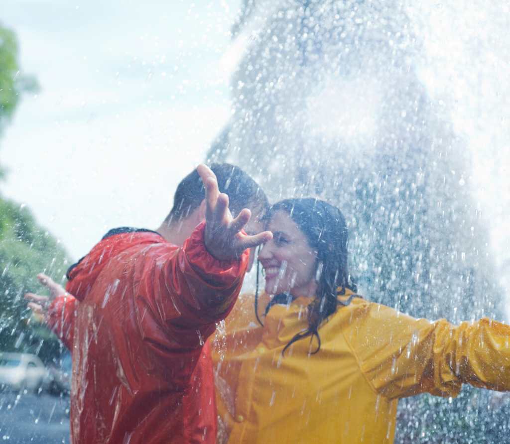 Feliz pareja bailando bajo la lluvia