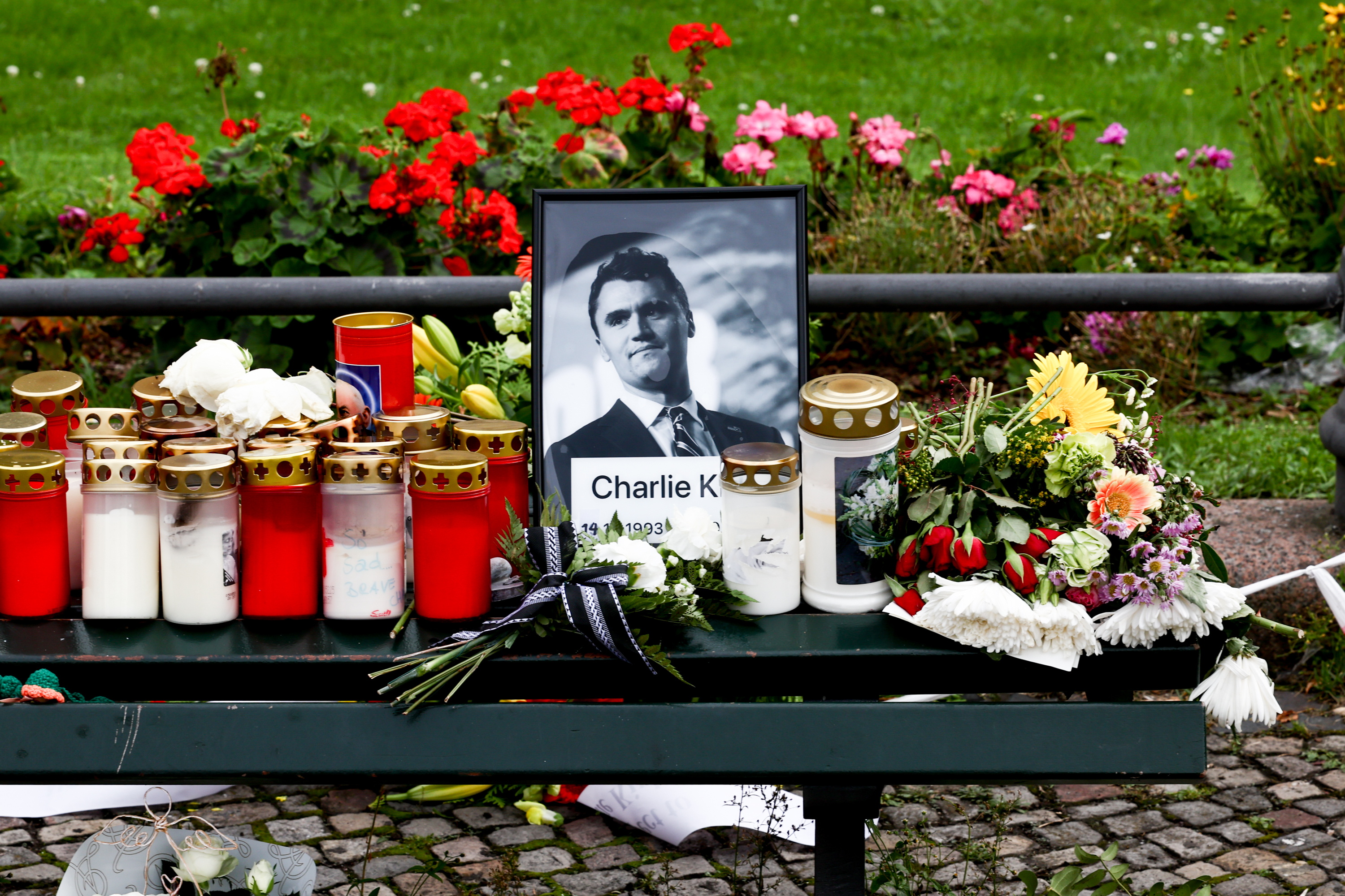 BERLIN (Germany), 13/09/2025.- Candles and flowers are placed in front of a photo of the slain US political activist Charlie Kirk during a vigil in reaction to his assassination, in Berlin, Germany, 13 September 2025. Kirk was fatally shot on 10 September at an event at Utah Valley University. The vigil was held near the Brandenburg Gate in front of the US embassy. (Alemania) EFE/EPA/FILIP SINGER