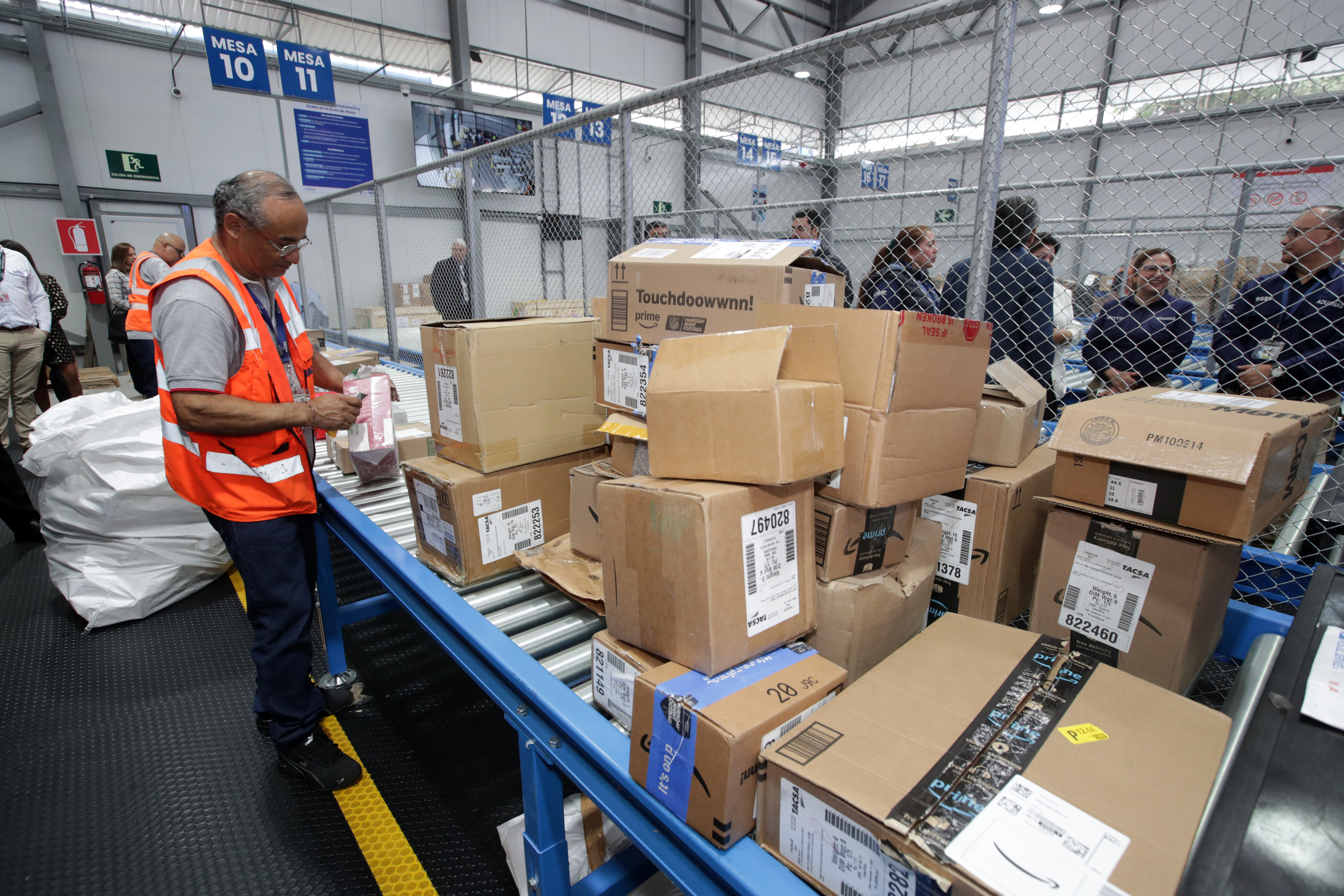 trabajadores revisando paquetes en Combe-Im en bodegas ampliadas por crecimiento de comercio electrónico