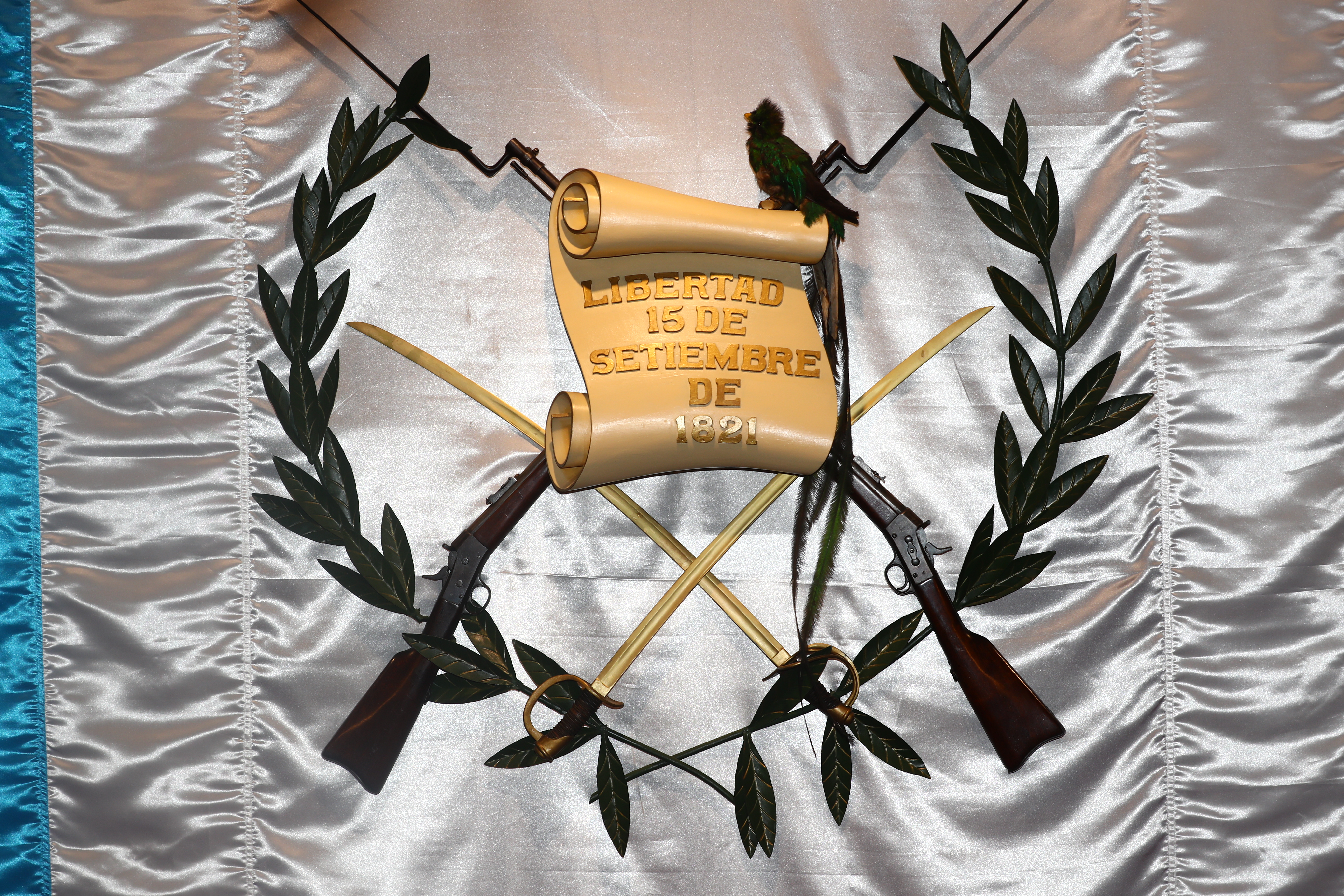 El Escudo de Armas, insignia suprema de la República de Guatemala, se compone de cinco elementos: El Quetzal, dos rifles Remington cruzados, dos espadas, corona de laurel, y un pergamino con la leyenda: "Libertad 15 de Septiembre de 1821", recordando el día en que Guatemala proclamó su independencia de España. (Foto Prensa Libre: Hemeroteca PL)