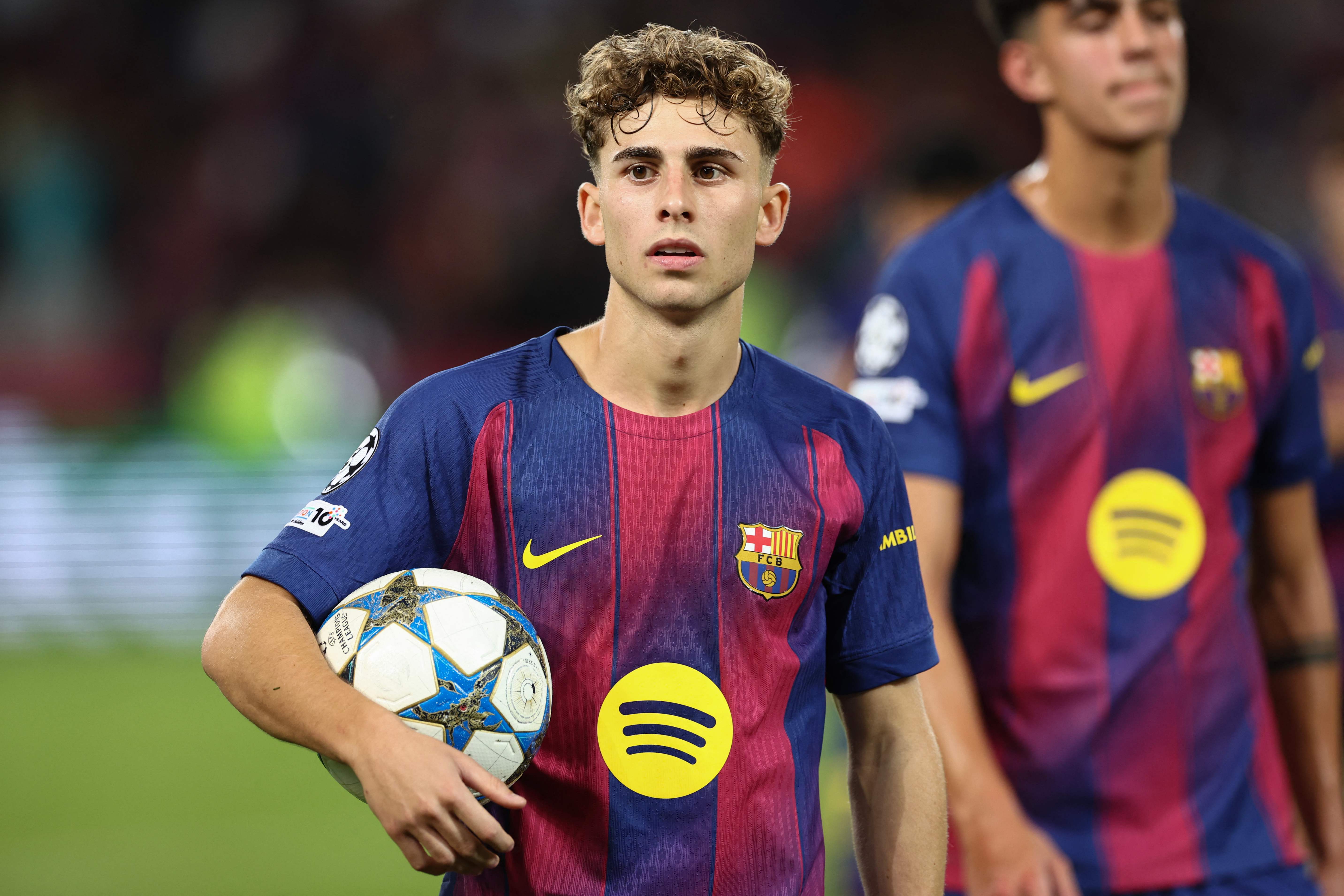 Barcelona's Spanish midfielder #16 Fermin Lopez carries the ball after scoring three goals for a hat trick in the UEFA Champions League league phase match-day 3 football match between FC Barcelona and Olympiakos FC at Estadi Olimpic Lluis Companys in Barcelona on October 21, 2025. Barcelona won 6-1. (Photo by Josep LAGO / AFP)