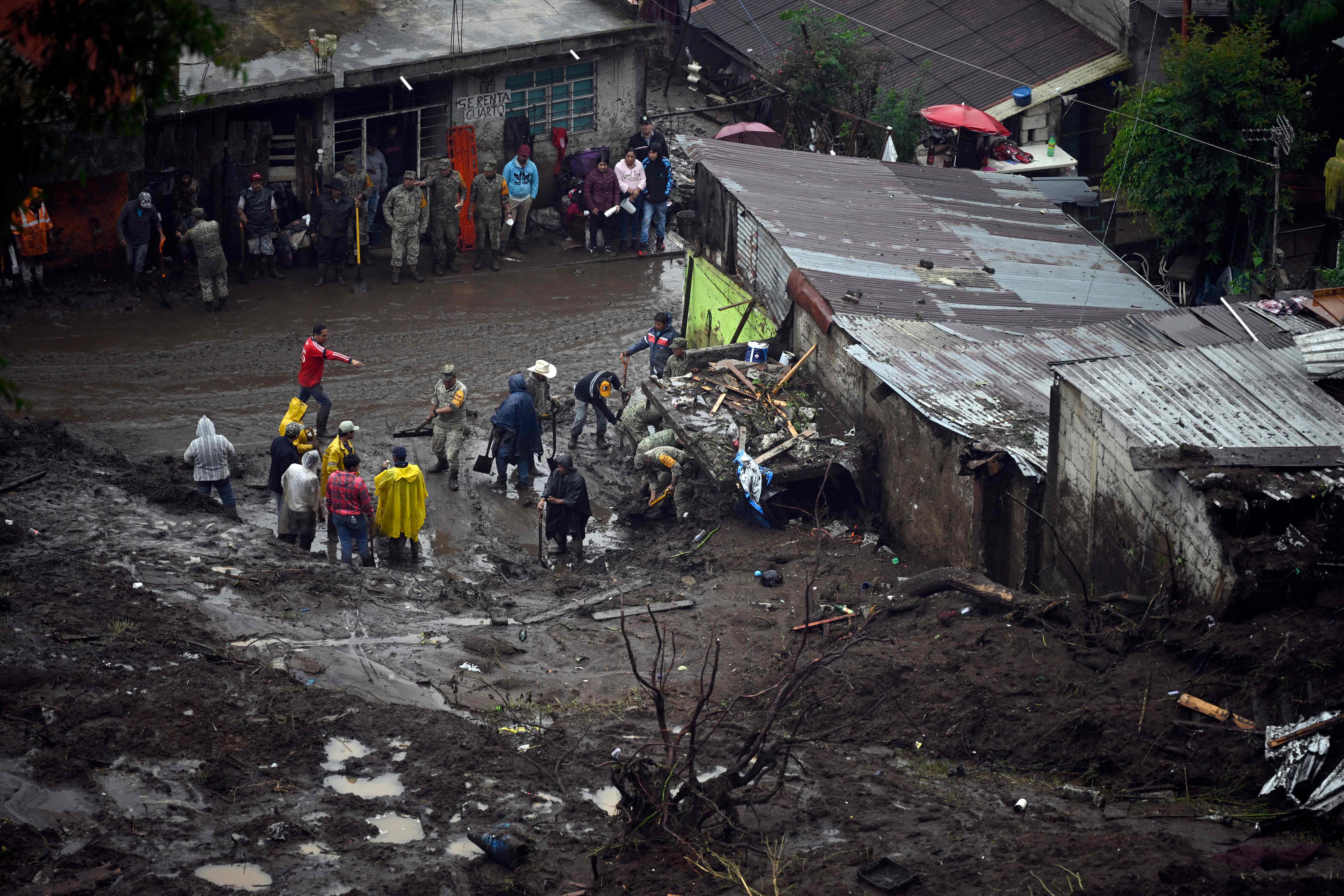 People work on a damaged house due to the rains in the municipality of Huauchinango, Puebla State, Mexico on October 11, 2025. The death toll from heavy rains in Mexico rose to 37 on Saturday after nine more fatalities were confirmed, the Mexican government reported. (Photo by Alfredo ESTRELLA / AFP)
