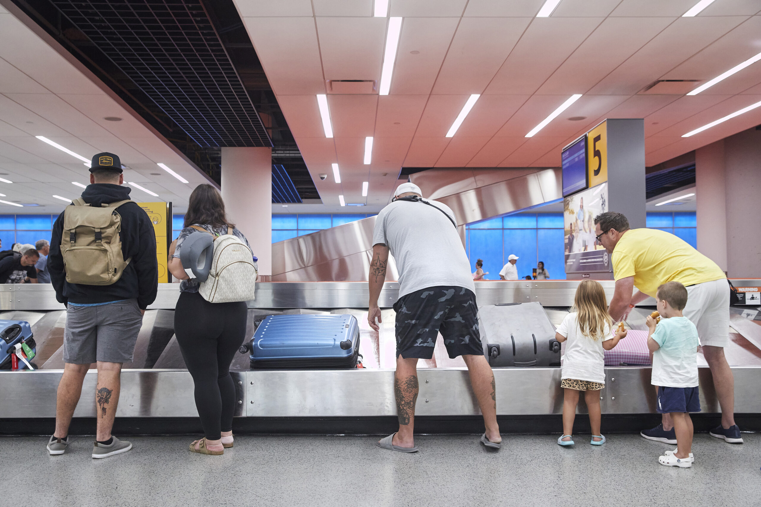 FILE Ñ Flyers reclaim their baggage at John F. Kennedy International airport in New York, July 29, 2022. Airline passengers are feeling the pain in rising fees, as the war in Iran weighs on the price of jet fuel. Loyalty programs and certain credit cards can help ease the burden. (Gus Powell/The New York Times)