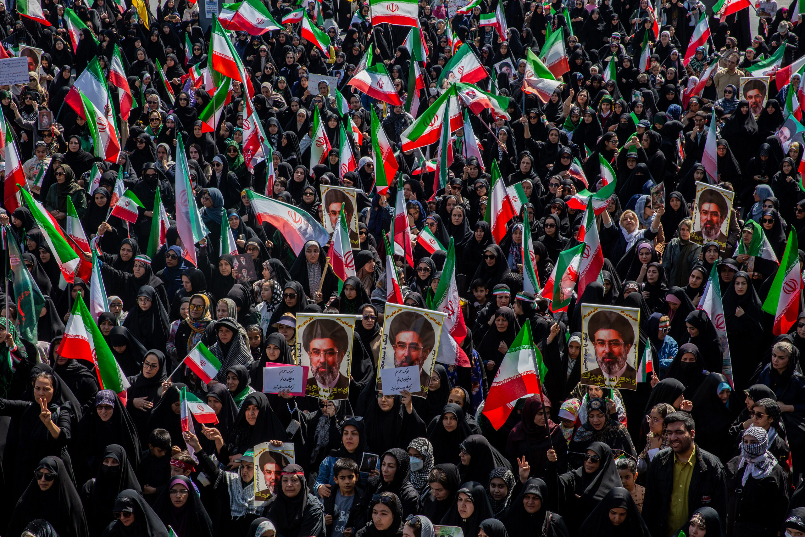 People chant and hold images of Mojtaba Khamenei, IranÕs supreme leader, during a government-organized rally in support of him marking National GirlsÕ Day in Tehran, Iran, on Friday, April 17, 2026. The United States military last week extended its blockade on vessels coming in and out of Iranian ports to the waters of the wider world, declaring that it would pursue any ship aiding Iran, regardless of location on the high seas or flag. (Arash Khamooshi/The New York Times)