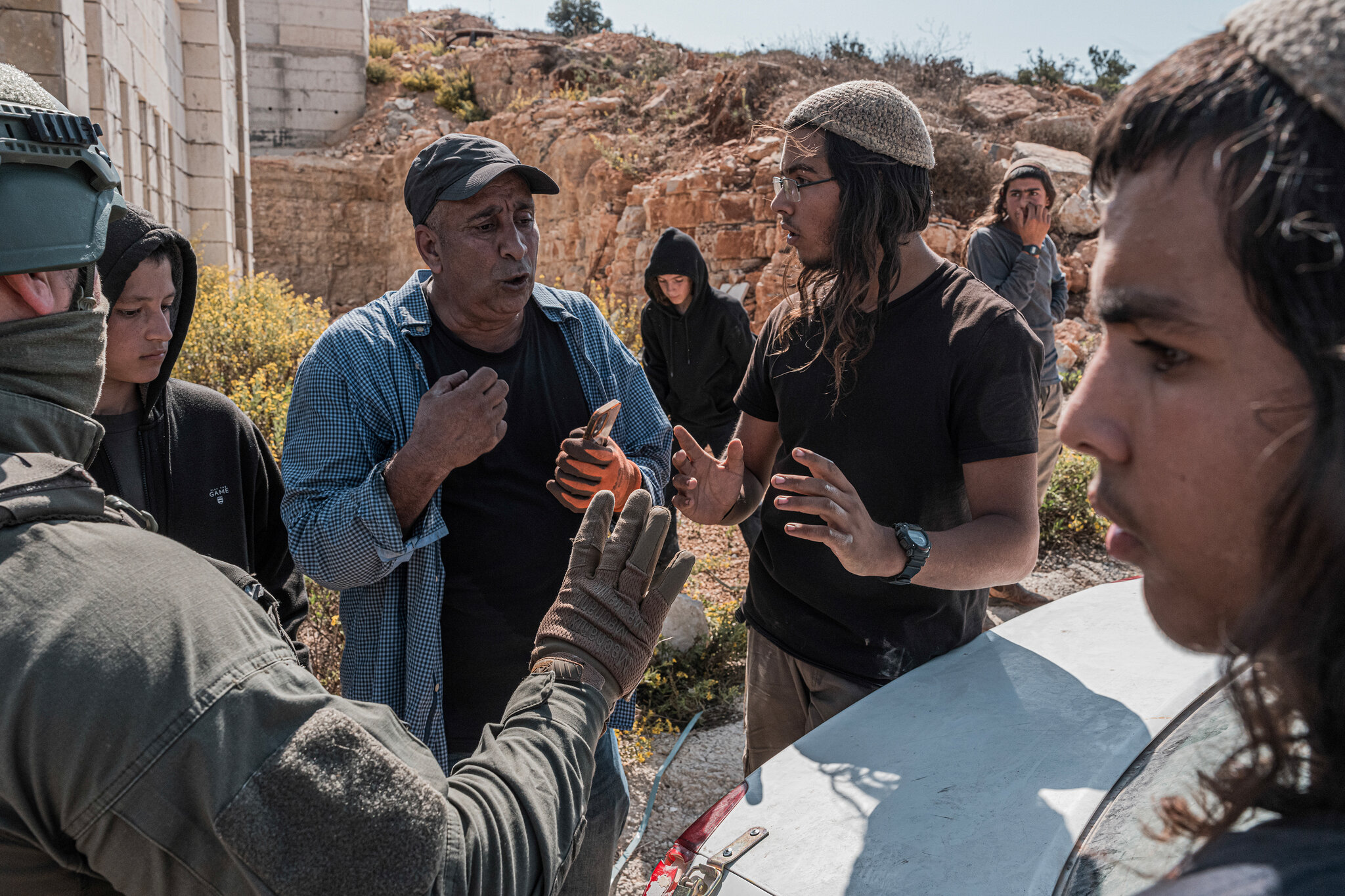 Colonos israelíes bloquean una carretera mientras intentan impedir que los agricultores palestinos abandonen sus tierras tras cosechar sus olivos en el pueblo de Silwad, cerca de Ramala Oriental, en octubre. Daniel Berehulak/The New York Times
