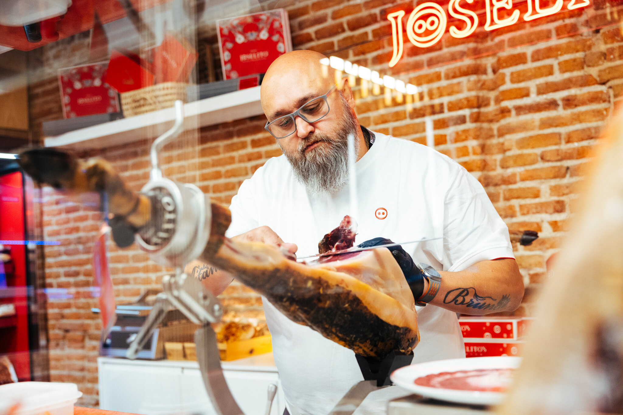 Ernesto Soriano trabajando en la tienda insignia de Joselito en Madrid el mes pasado. Empezó a aprender a cortar a los 15 años. Gianfranco Tripodo para The New York Times
