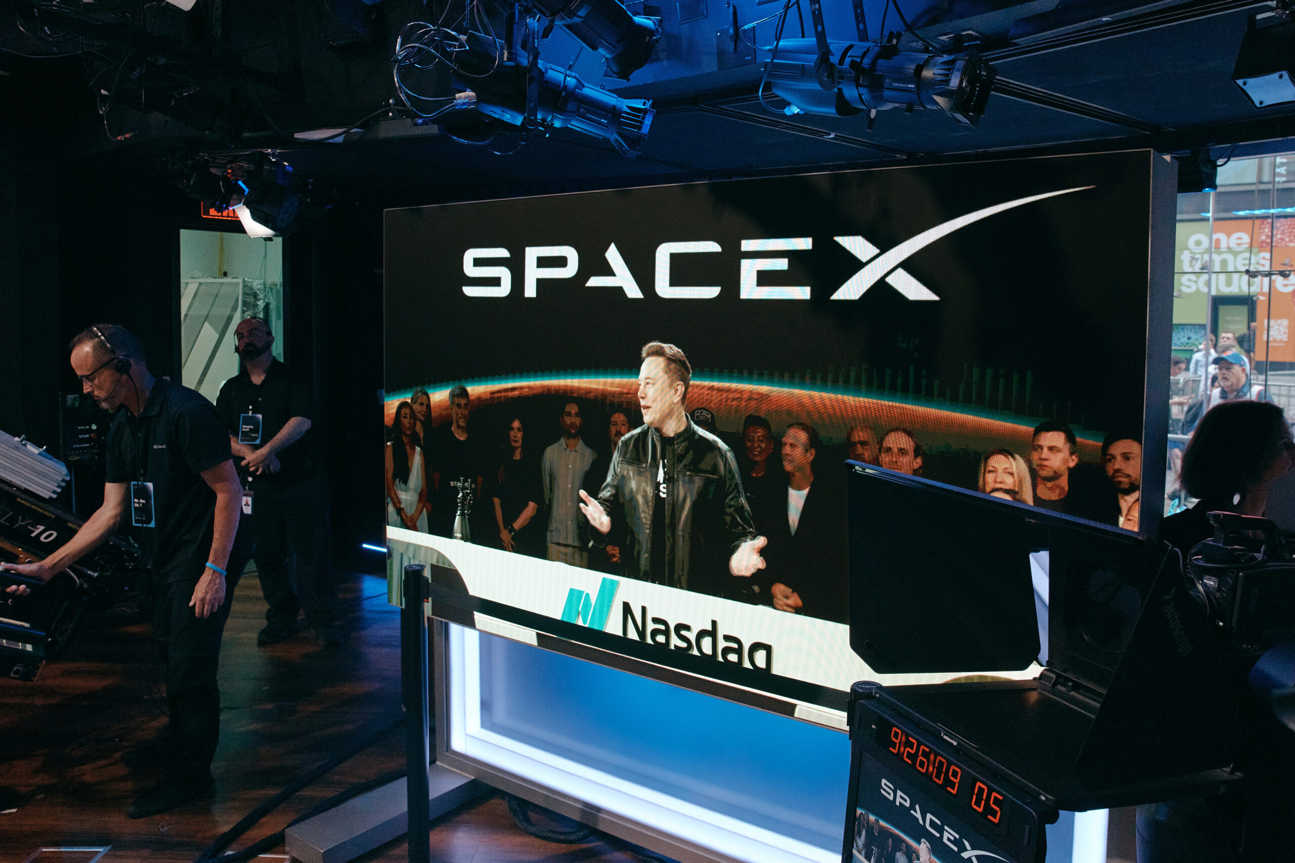 Elon Musk is visible on a video feed from Starbase, the Texas headquarters of SpaceX, at the Nasdaq stock exchange in New York on Friday morning, June 12, 2026. Musk became the world's first trillionaire on June 11, 2026, as shares of his rocket company SpaceX began trading on the stock market at $150, up 11 percent from their initial public offering price. (Andres Kudacki/The New York Times)