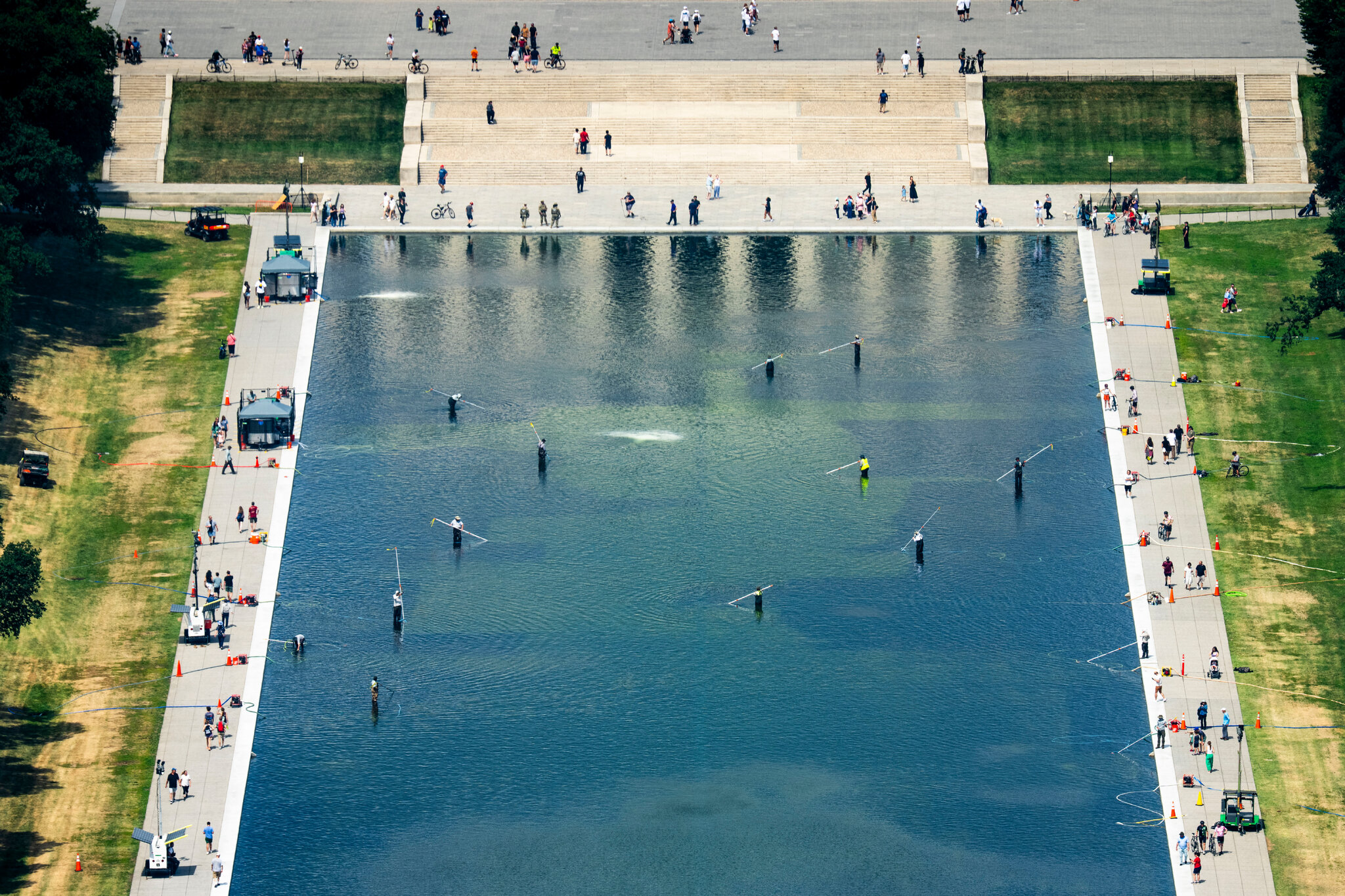 El estanque reflectante, visto desde el Monumento a Washington, con trabajadores intentando controlar las algas el domingo. Doug Mills/The New York Times