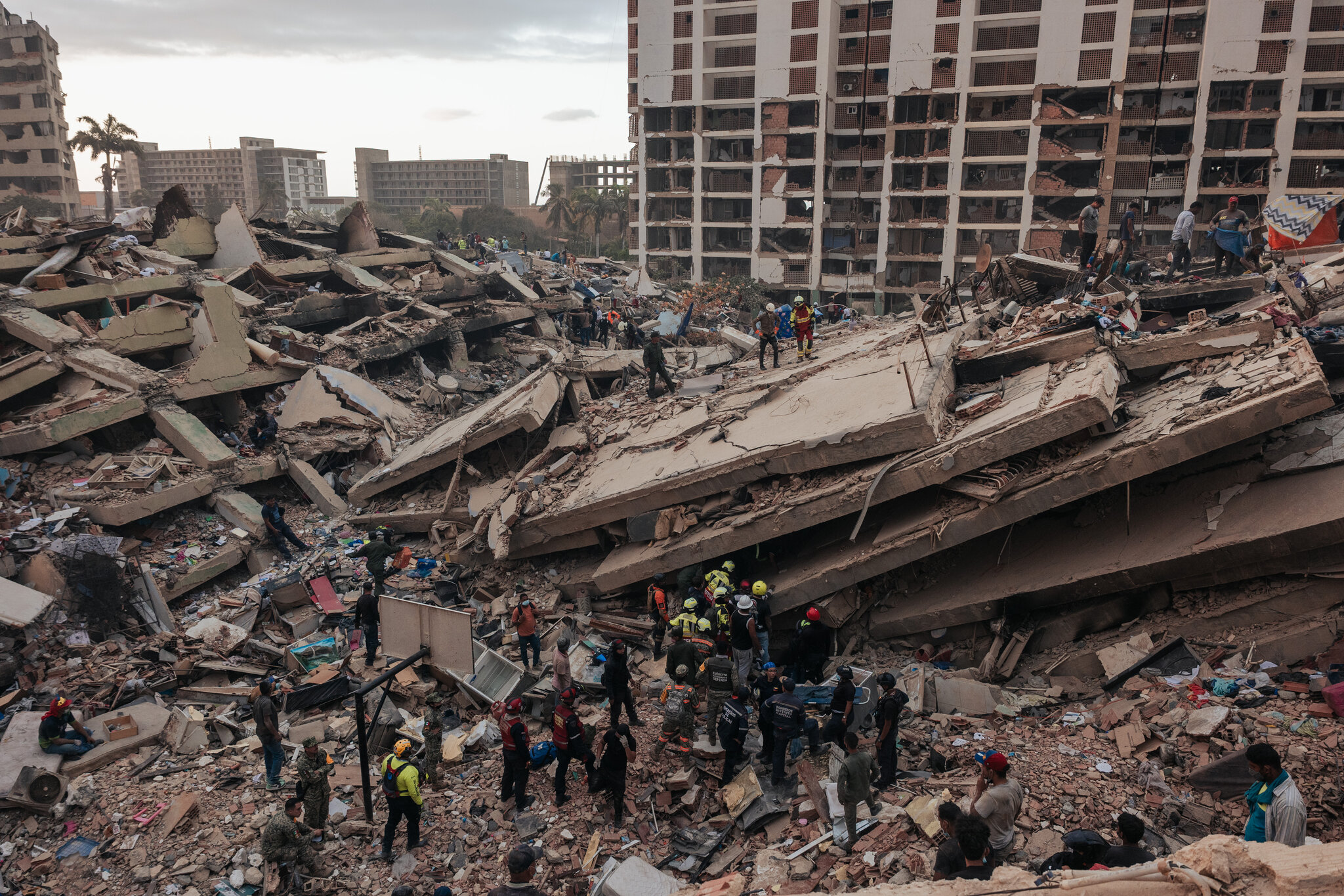 Equipos de rescate, civiles y personal médico de urgencias buscan supervivientes entre los escombros de varios edificios derrumbados, en La Guaira, Venezuela, el sábado. Adriana Loureiro Fernandez para The New York Times