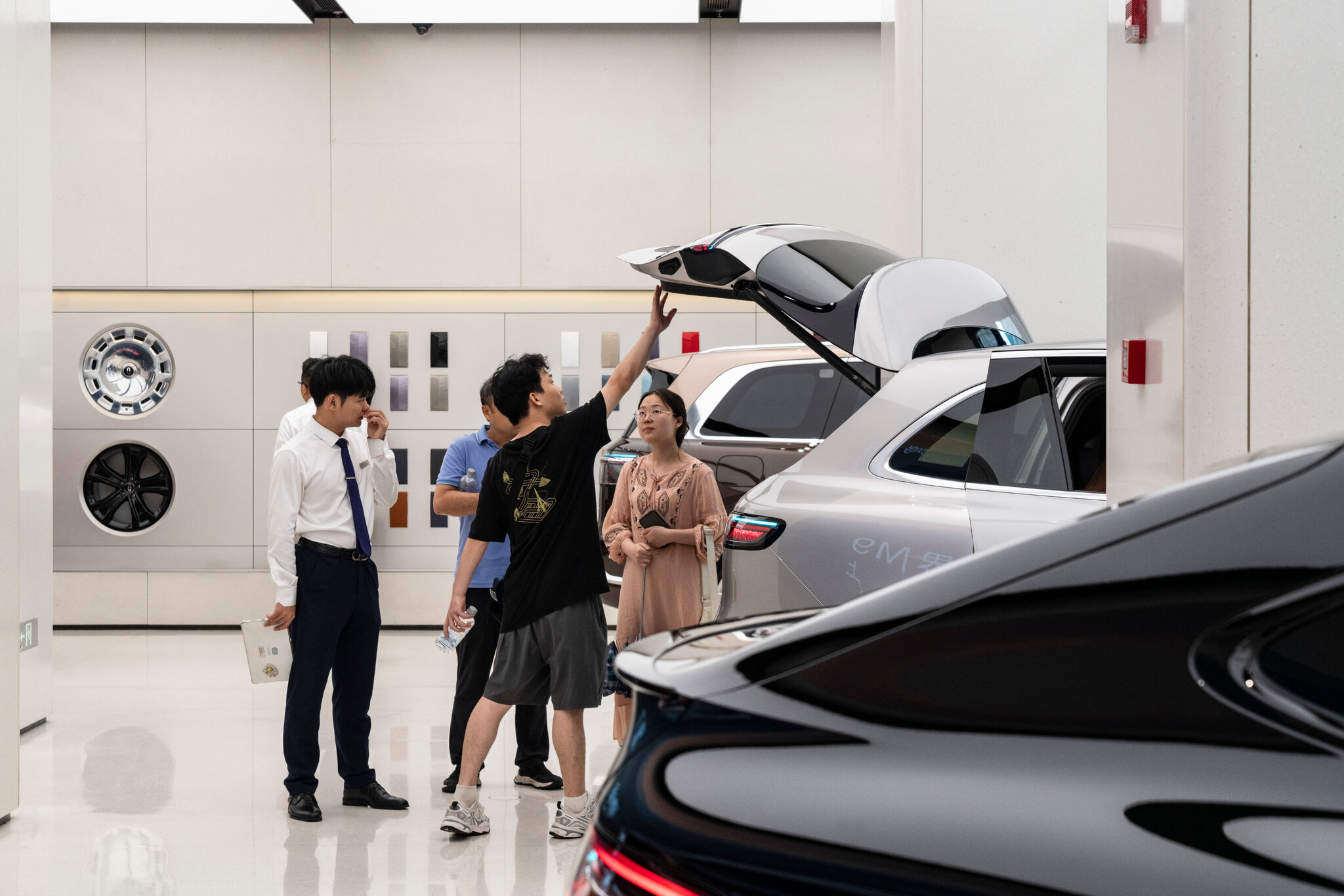 Compradores en una sala de exposición de automóviles eléctricos en Shanghái. Los consumidores chinos han adoptado una cultura de ahorro, ya que muchos no sienten los beneficios del crecimiento económico. Qilai Shen para The New York Times