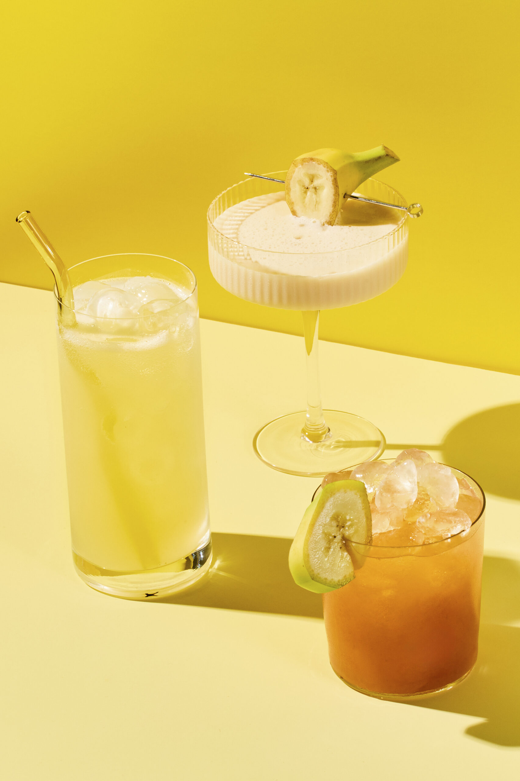 Banana drinks like Ollipop's banana cream soda, left, Cutwater's banana mudslide and Banagua, a new banana water, are increasingly common in grocery store beverage refrigerators across the country. The familiarity of banana has made it ripe for beverage and snack experimentation. Food Stylist: Megumi Emoto. (Julia Gartland/The New York Times)
