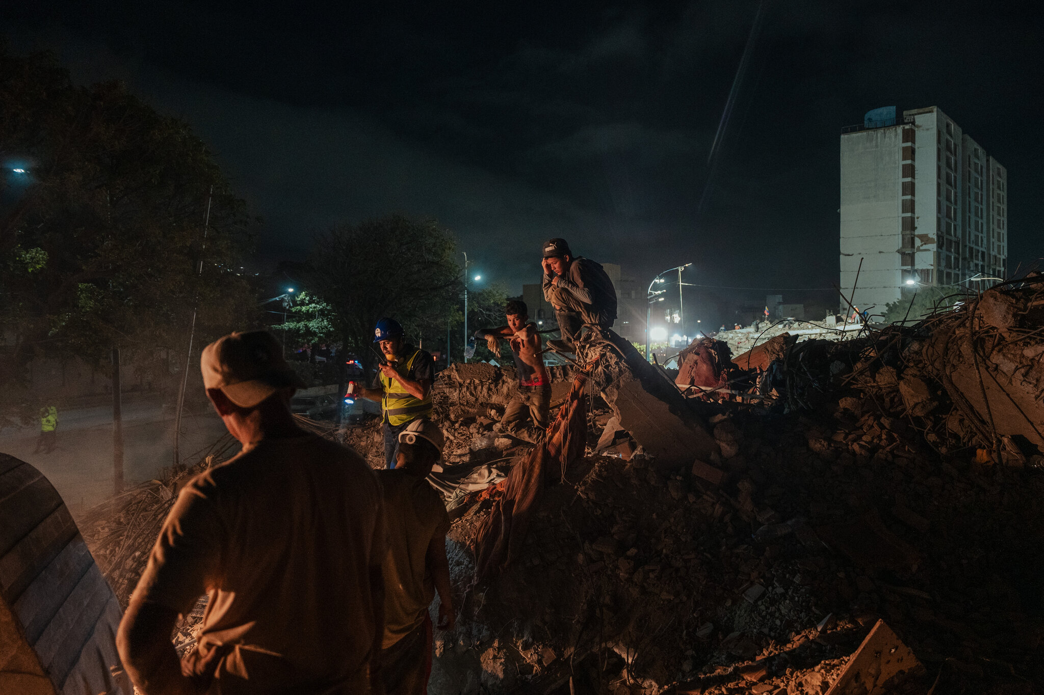 Winder Delfín, 17, right, and his brother Deivi, 15, during the 24th day of searching for their mother, younger brother and grandmother, who lived on the first floor of a twelve story building that collapsed during the twin earthquakes last month. Adriana Loureiro Fernandez for The New York Times