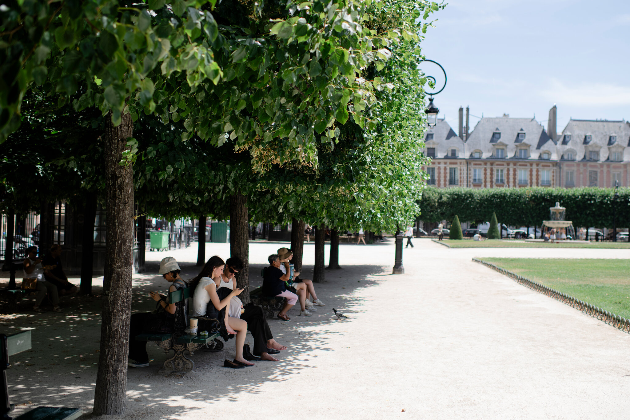 Seeking shade in the Place des Vosges in Paris during the June heat wave. Dmitry Kostyukov for The New York Times