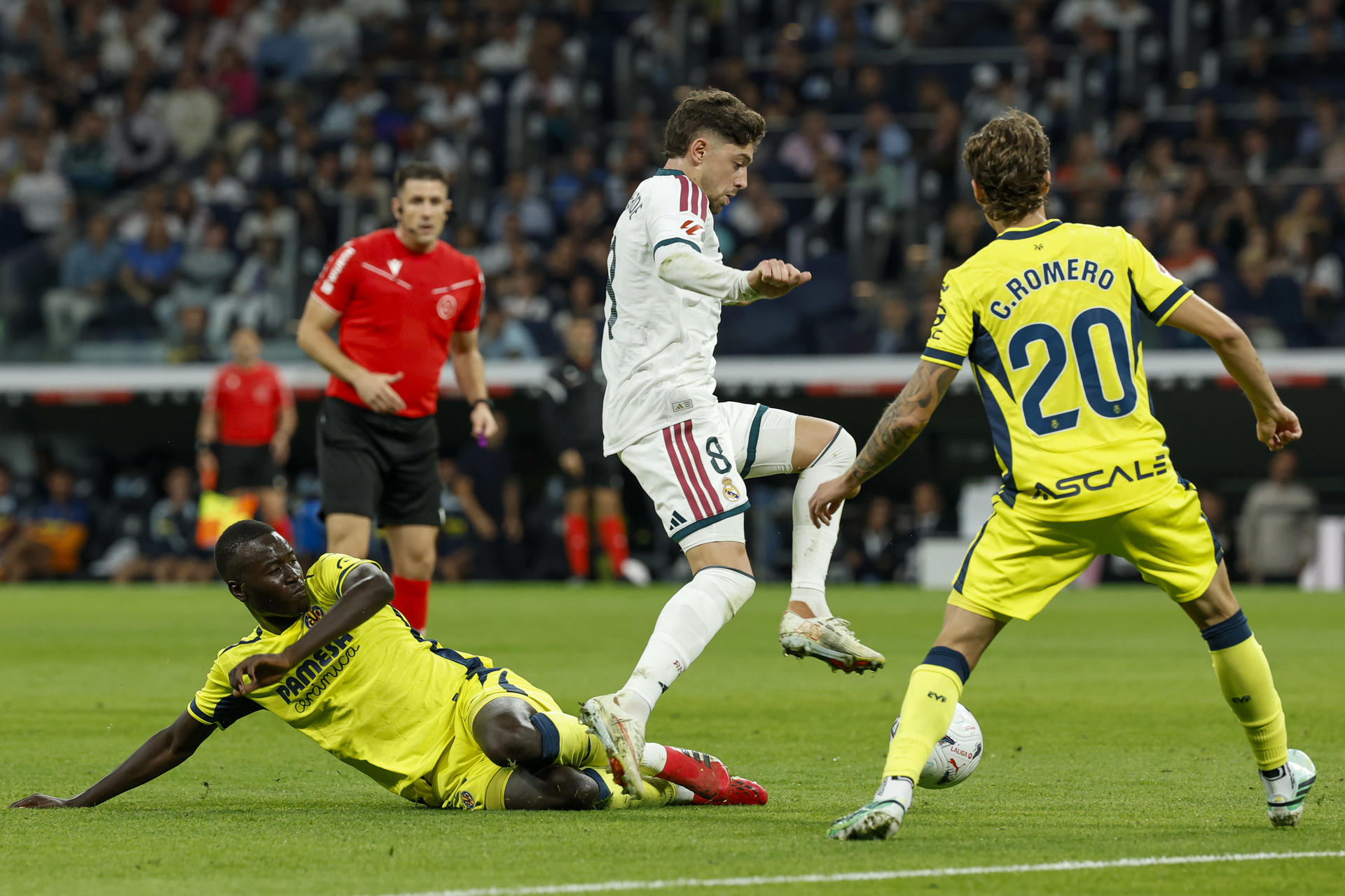El centrocampista del Real Madrid Federico Valverde (c) supera la defensa de Pape Alassane Gueye (i), del Villarreal CF, durante el partido de LaLiga de fútbol que Real Madrid y Villarreal CF disputaRON en el estadio Santiago Bernabéu. EFE/Chema Moya