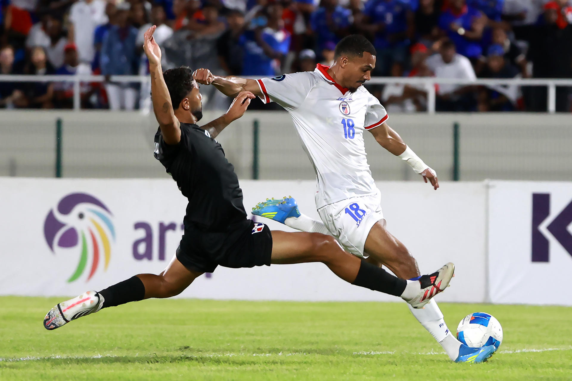 Noah Dollenmayer (i), de República Dominicana, disputa el balón con Wilson Isidor, de Haití, en un partido de la Liga de Naciones Concacaf entre República Dominicana y Haití en el estadio olímpico Félix Sánchez en Santo Domingo (República Dominicana). EFE/Orlando Barria
