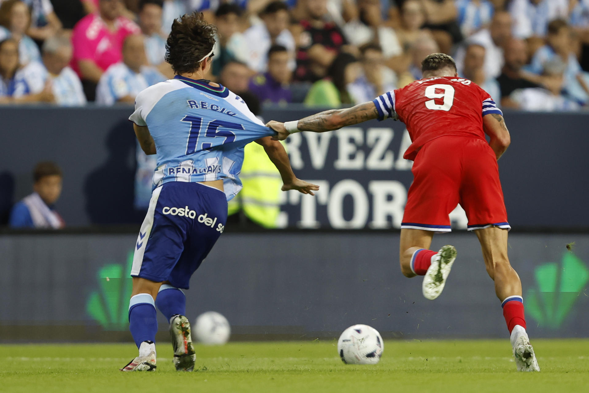 El delantero del Espanyol Roberto Fernández (d) agarra a Ángel Recio, del Málaga, durante el partido de LaLiga de fútbol que Málaga CF y RCD Espanyol disputan en el estadio de La Rosaleda. EFE/Jorge Zapata